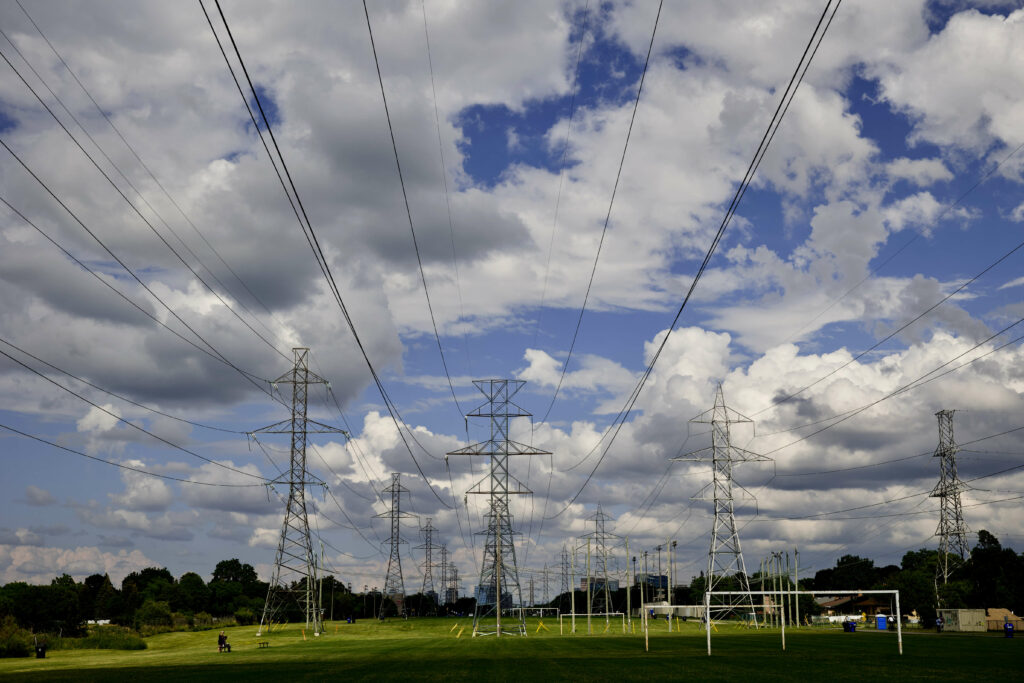 rows of hydro towers in field with clouds above