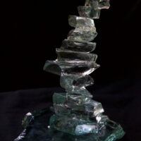 A twisted staircase glass miniature made from broken green glass with a flat glass top