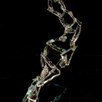 A twisted and contorted ladder made from pieces of broken green and clear glass